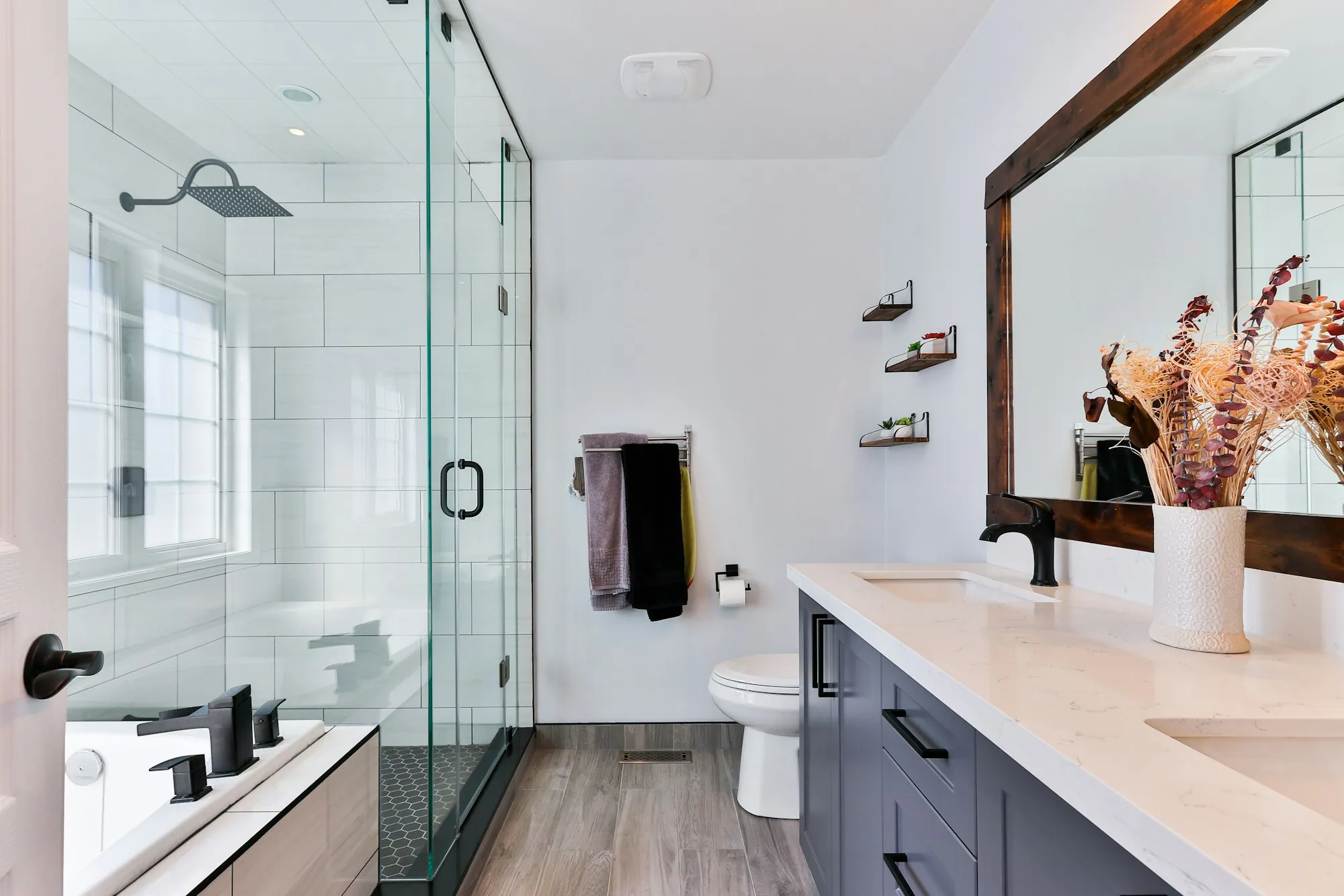 Salle de bain rénovée avec douche vitrée et vanité