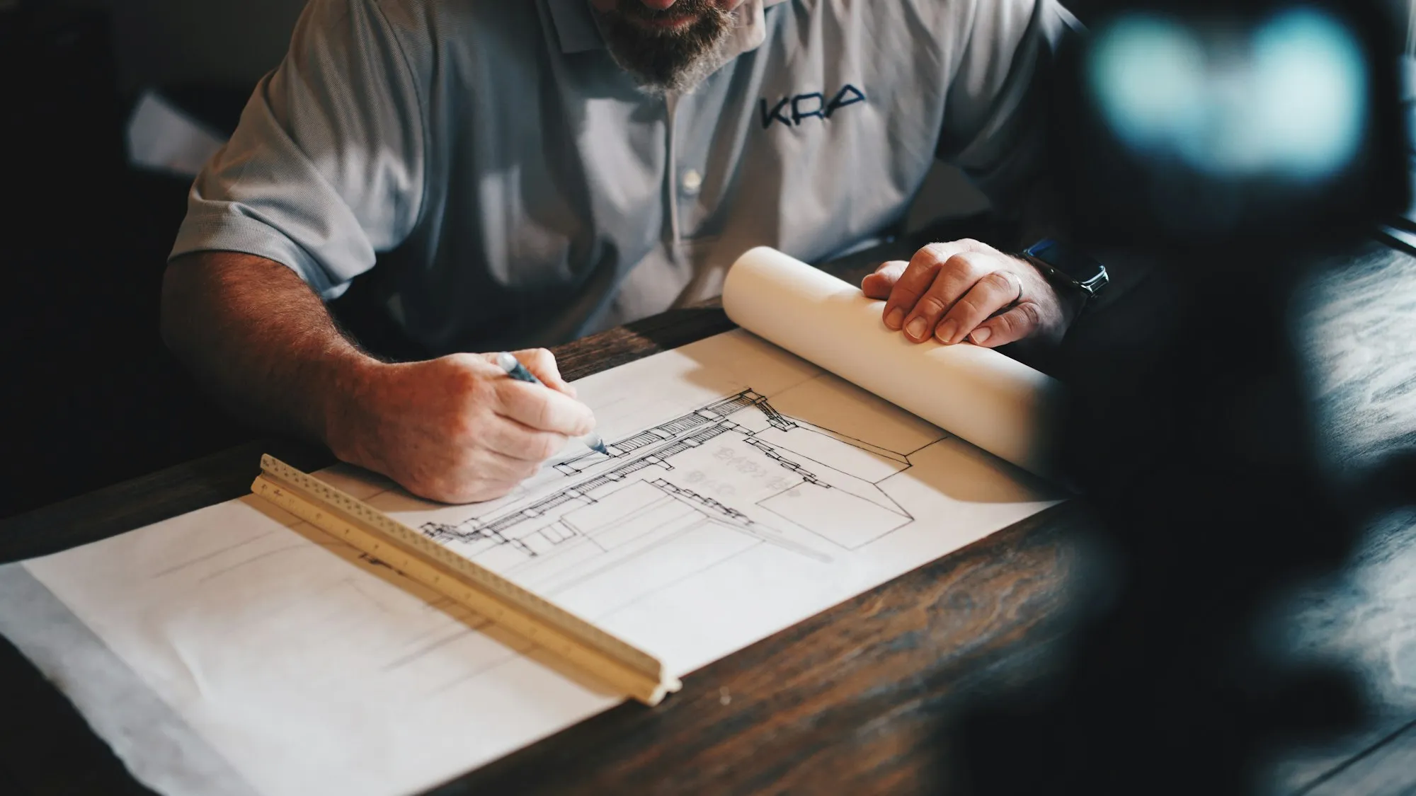 Plans d’architecture annotés à la main sur une table à dessin